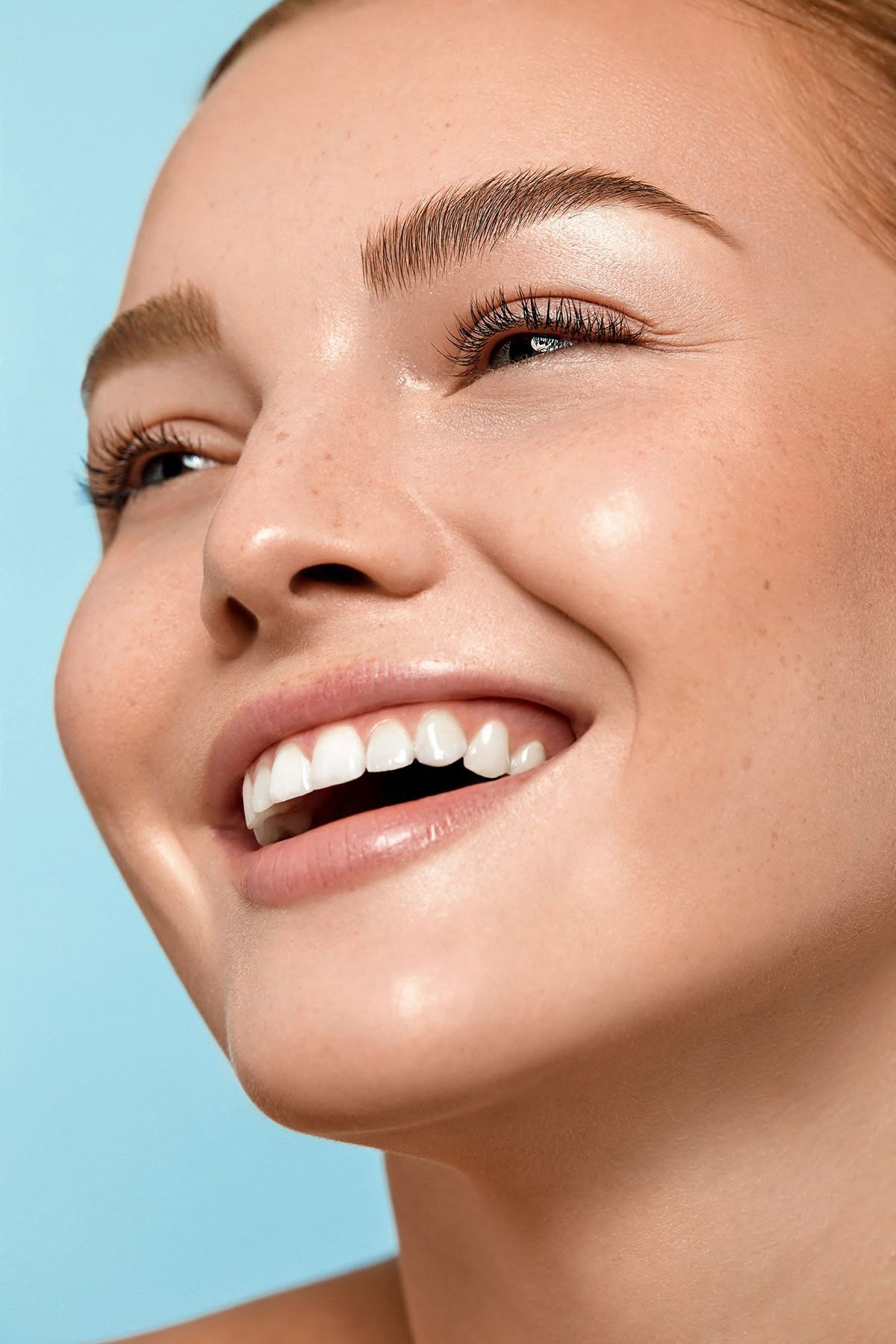 Close-up of a smiling face with clear, dewy skin