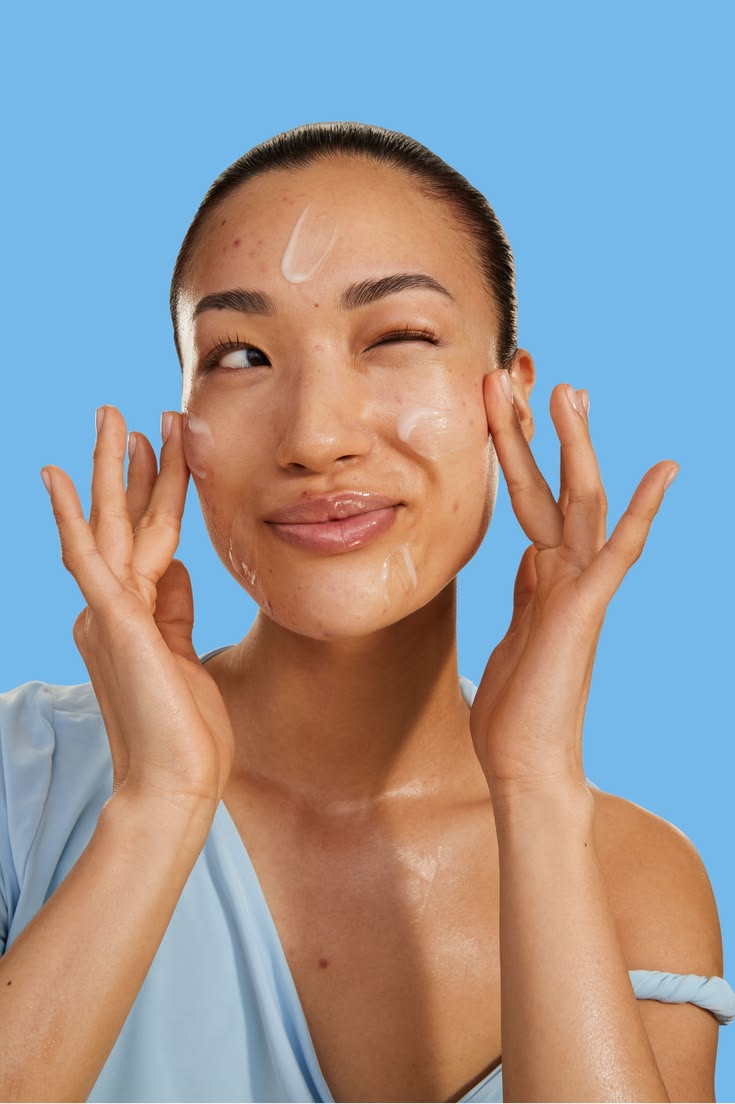 Woman patting skincare into her cheeks