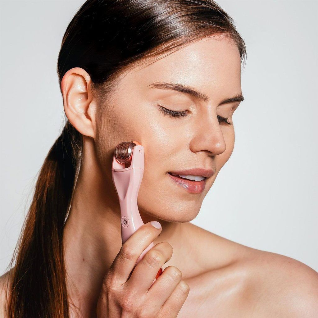 Woman using a facial roller along her jawline